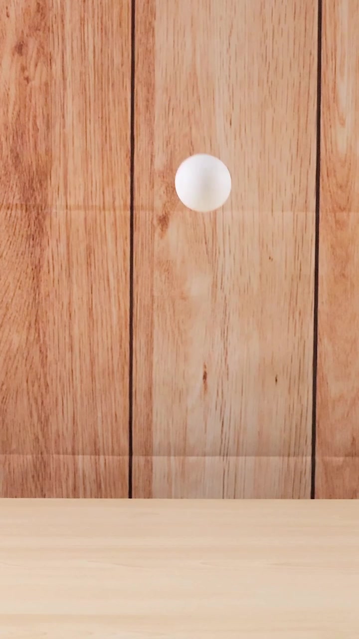 A ball moves across a wooden surface
