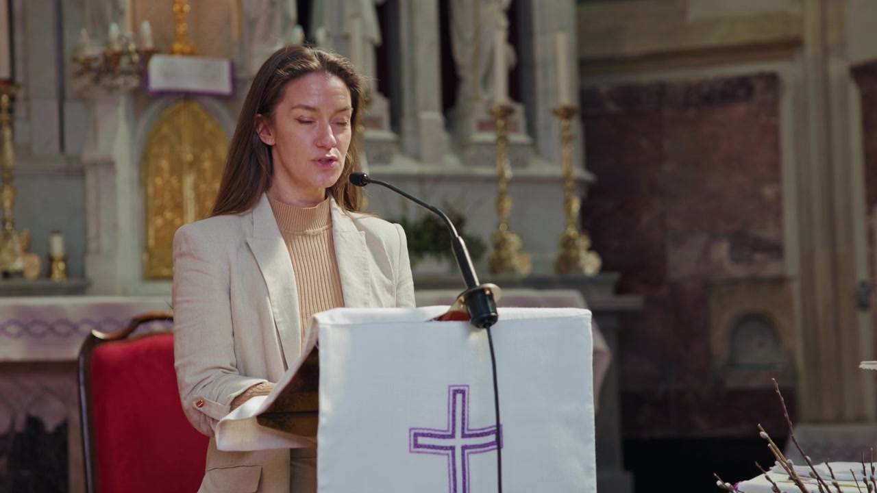 Lettrice nella chiesa cattolica in piedi dietro il pulpito che legge le scritture al microfono