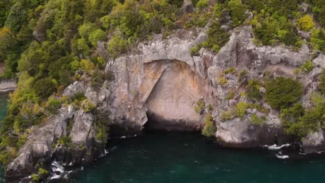 maori artwork carved in rocky cliff on lake taupo coast