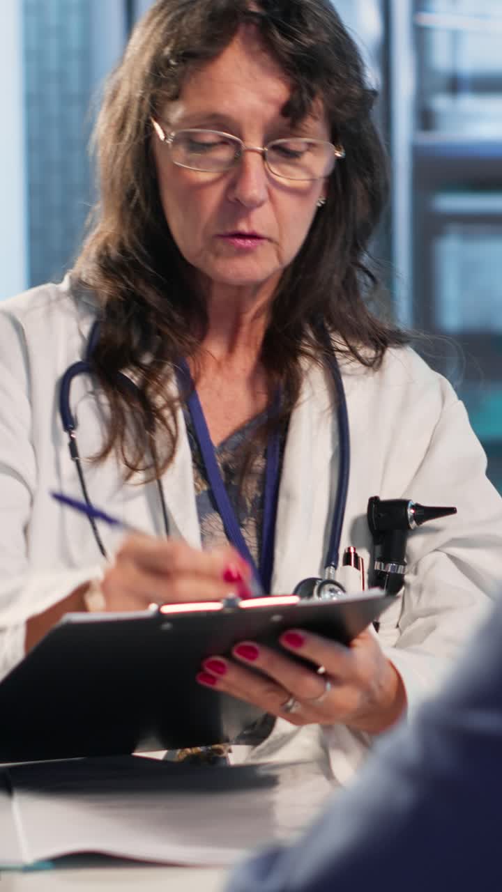 Vertical Video Skilled medical expert analyzing x ray scans for old patient on insurance