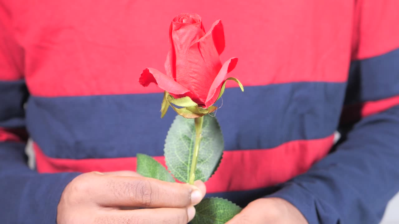 단 하나의 빨간 장미를 들고 있는 사람