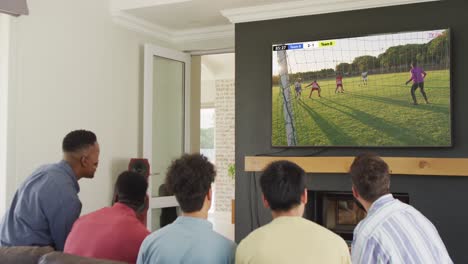 Diverse-friends-supporting-and-watching-tv-with-diverse-male-soccer-players-playing-match-on-screen