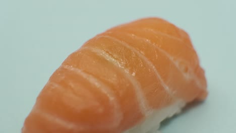 fotografía de estudio de un rollo de sushi sobre un fondo azul