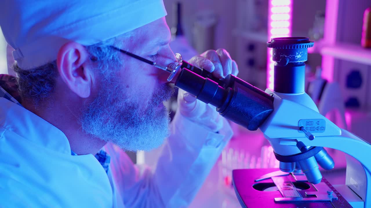 Scienziato che osserva al microscopio in un laboratorio moderno