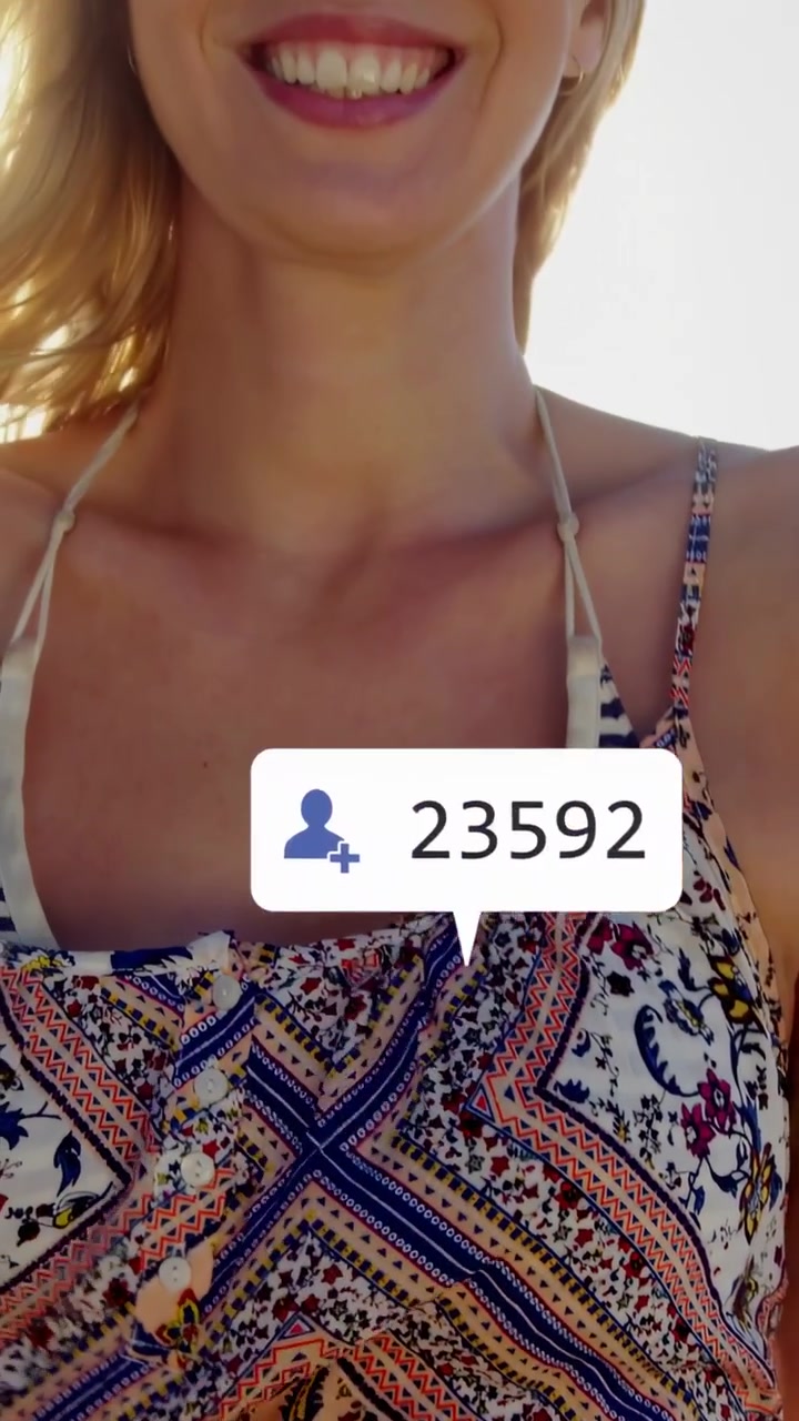 Vertical video: Woman riding beach, pan sparking social media likes around her, gaining engagement