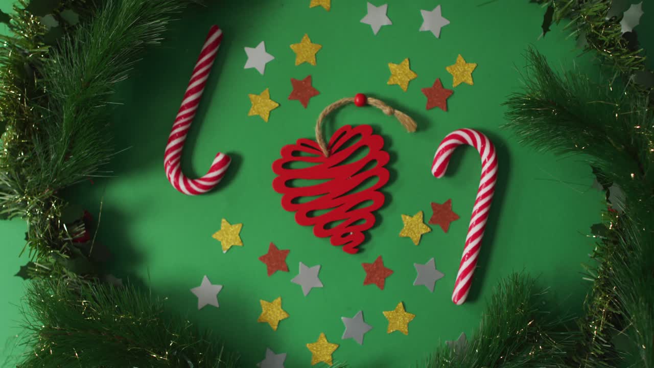 decoraciones de navidad y bastones de caramelo enmarcados con ramas de abeto sobre un fondo verde