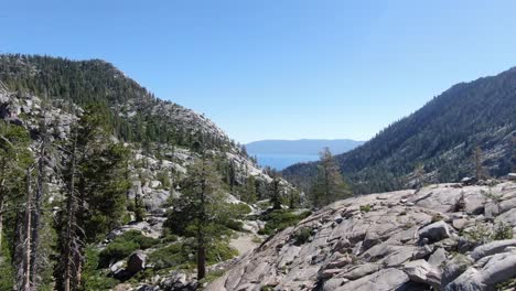 A-young-woman-hikes-up-a-ridge-while-backpacking-and-hiking-in-desolation-wilderness-in-the-sierra-Nevada-mountains-in-California-on-an-adventure-with-friends-and-family-in-the-summer