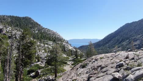 a young woman hikes up a ridge while backpacking and hiking in desolation wilderness in the sierra nevada mountains in california on an adventure with friends and family in the summer