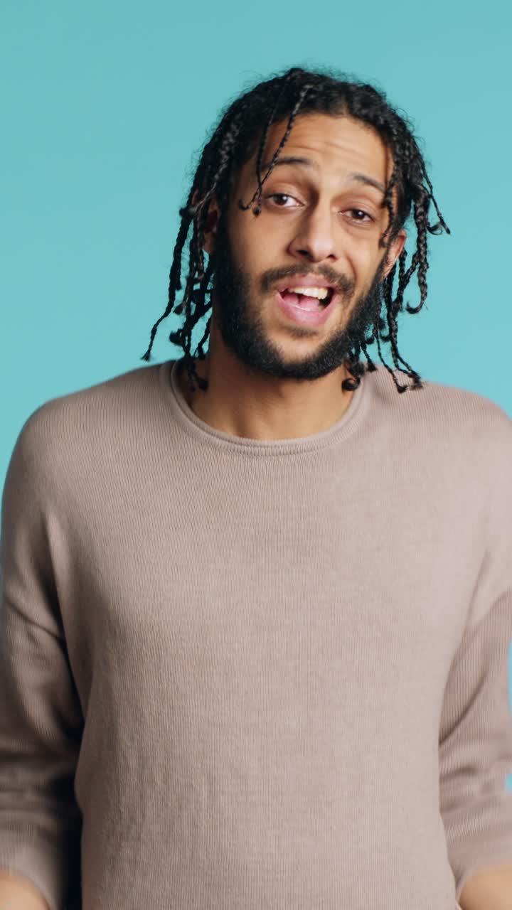 Vertical video Uncaring man shrugging shoulders, showing indifference, studio background