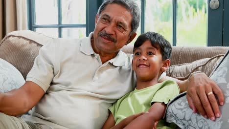 Grandfather-and-grandson-interacting-on-sofa-4k