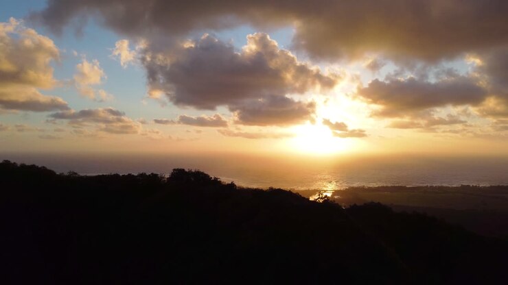 Metraje aéreo de un amanecer montañoso revelando una vista del Océano Pacífico
