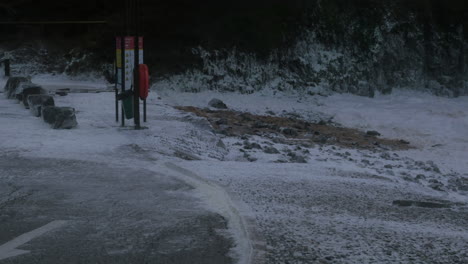 White-sea-foam-on-the-Chapel-Porth-Beach-in-Cornwall,-UK-during-storm-Ciara---wide-shot