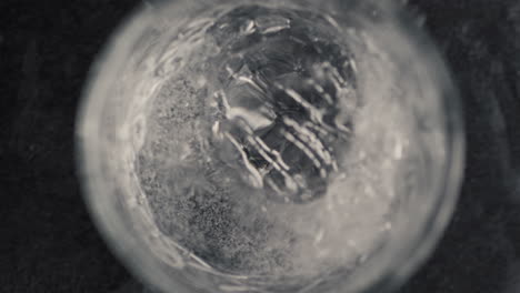 ice cube falling splashed mineral water glass closeup. making cocktail concept