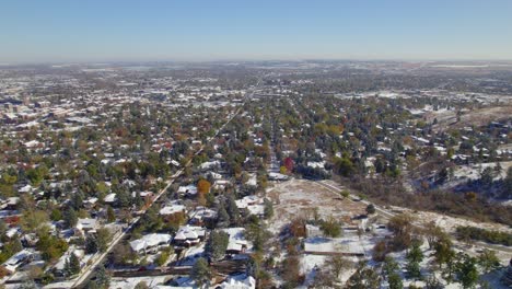 drone flight on a calm fall day with light snow on the ground above neighborhoods in boulder colorado usa