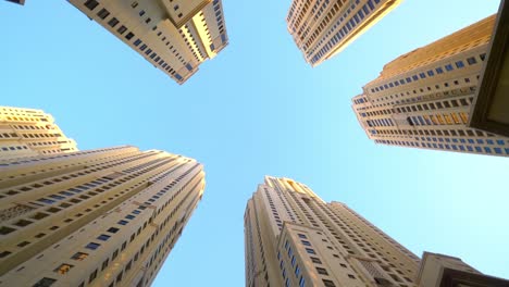 high rise buildings with blue sky - waterfront community of jumeirah beach residences in dubai marina in dubai, united arab emirates