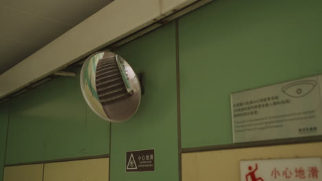 Dolly-in-shot-of-convex-traffic-mirror-reflecting-stairway