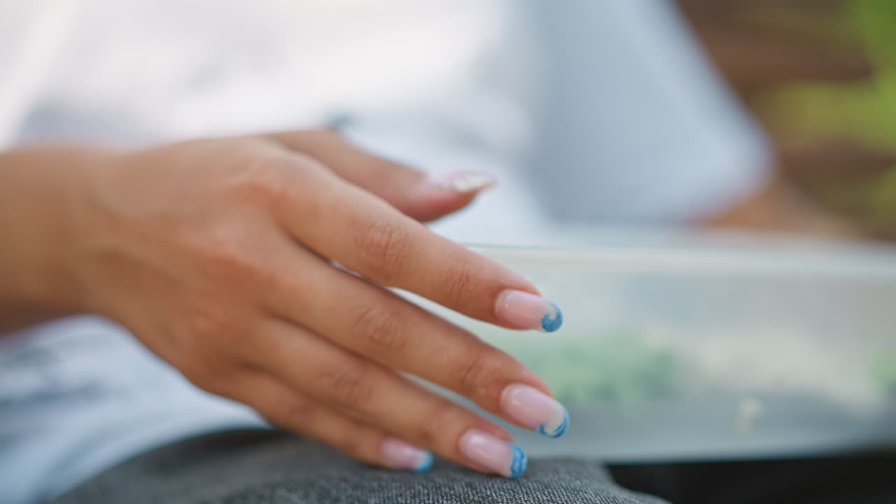 Hands preparing salad, Close view of hands organizing lettuce in container during peaceful moment, Detailed scene of hands delicately placing lettuce in container amidst calm park setting