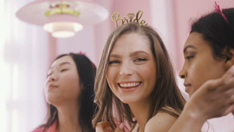 Close-Up-View-Of-Bachelor-Girl-With-Headdress-With-Bride-Word-Surrounded-By-Her-Friends