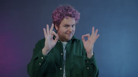 man with pink hair making an ok gesture