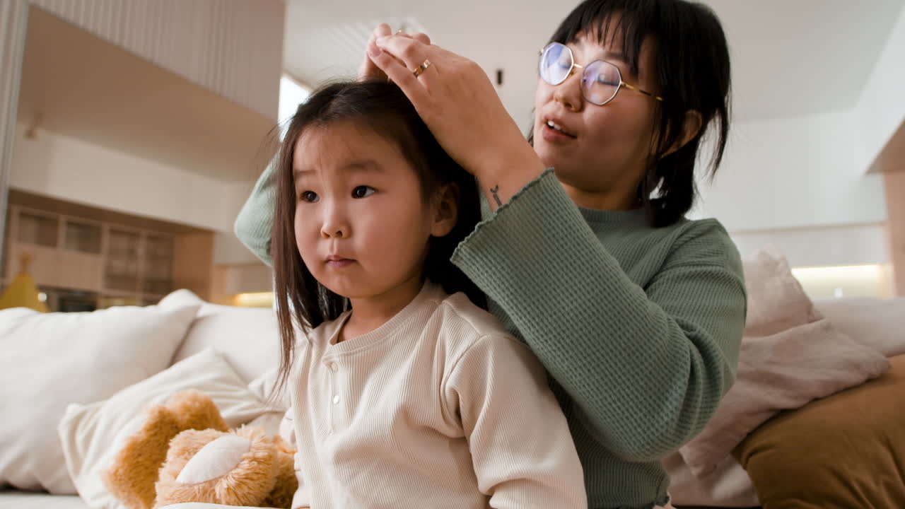 어머니 가 딸 의 머리 를 꾸미고 있다
