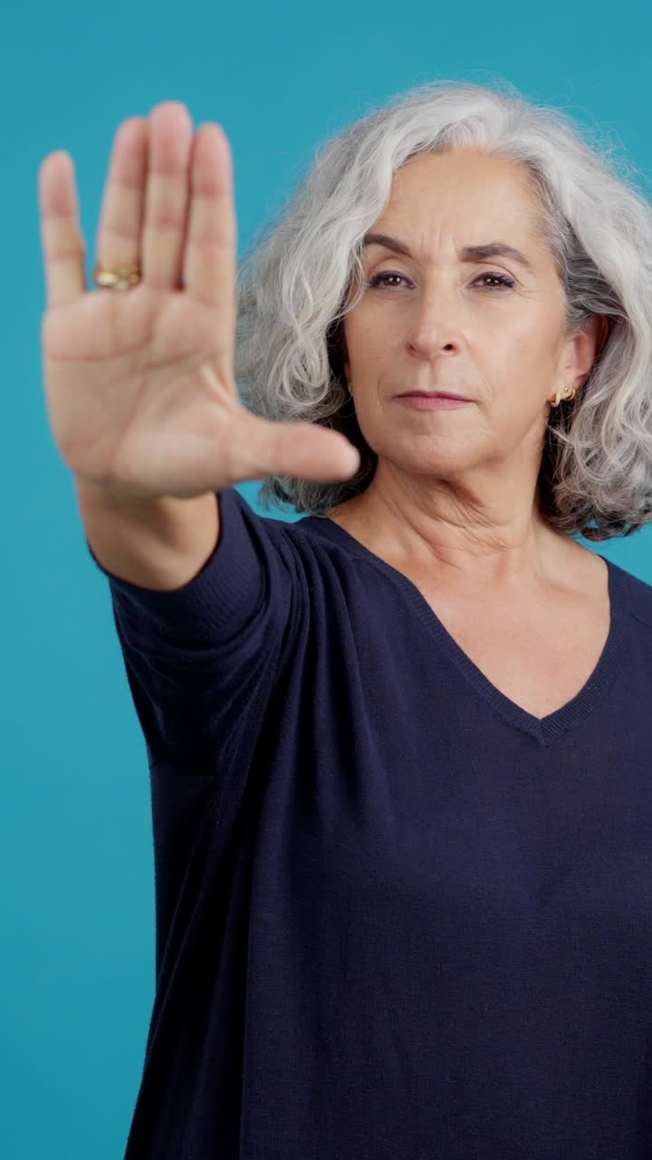 Mature Woman Making a Stop Gesture with Her Hand