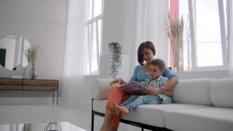 Mother-and-son-read-books.-Happy-young-mother-and-son-read-books-on-the-sofa-at-home