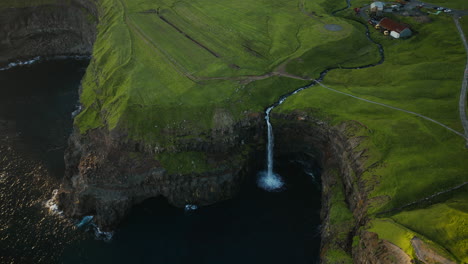 Aerial View of Múlafossur Waterfall Plunging into the Ocean from Green Cliffs