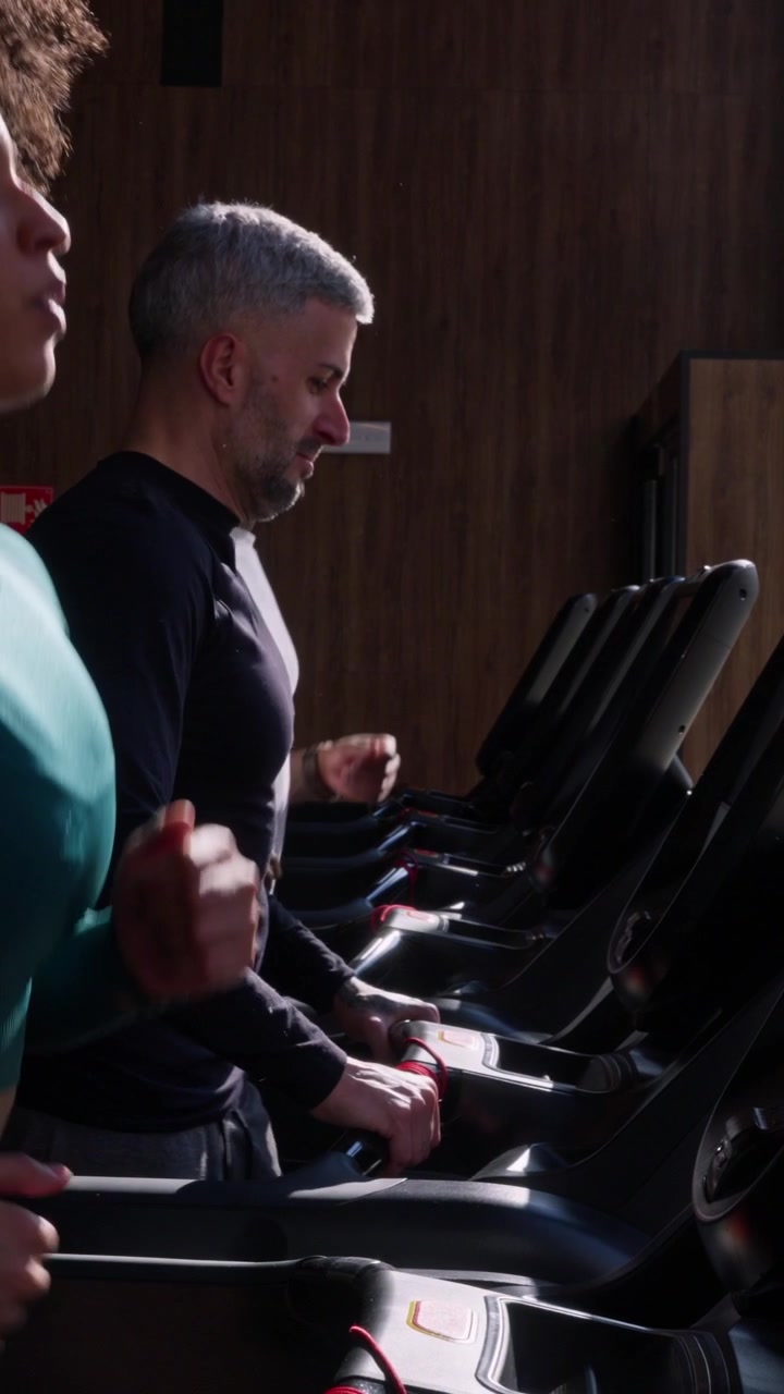 Diverse Group of People Running on Treadmills in Modern Gym
