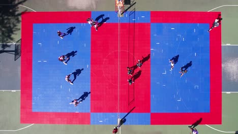 top down aerial view of volleyball teams playing the match on colorful outdoor court, drone shot