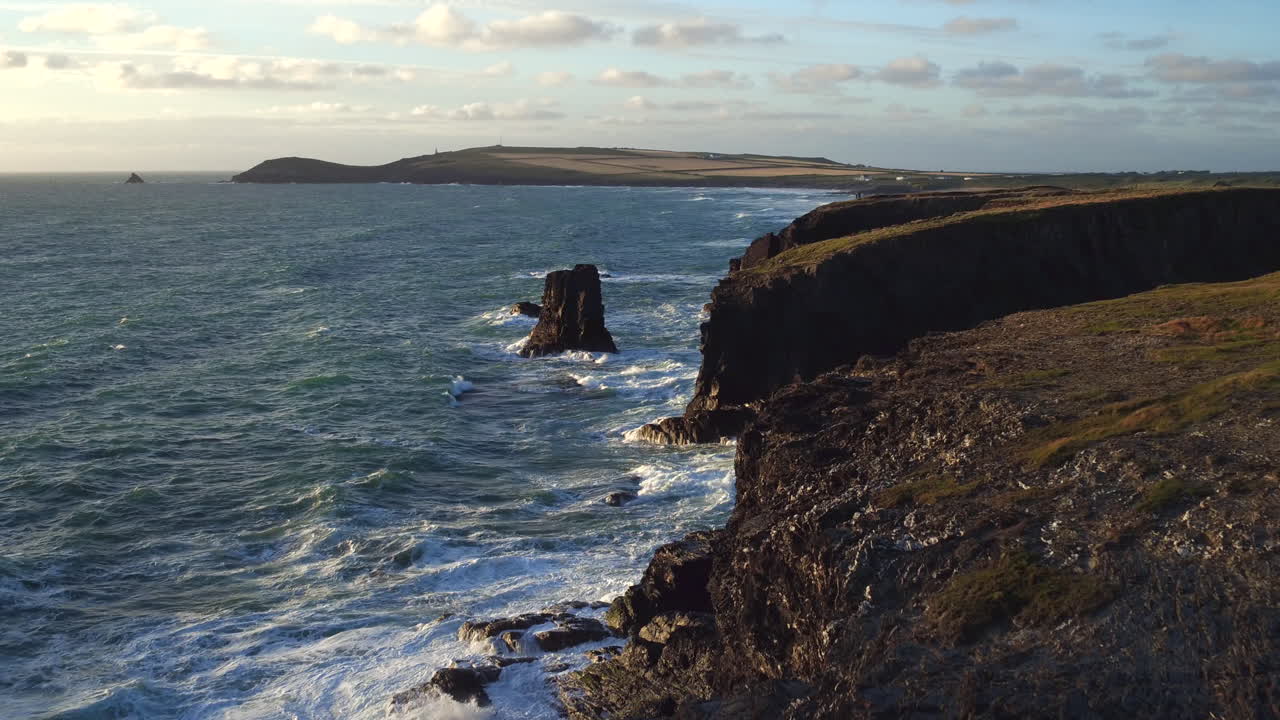 Stunning cinematic aerial shot gliding over a rugged cornish coastline
