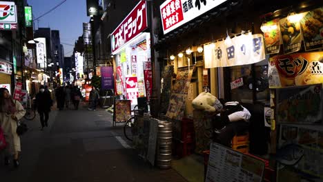 pedestrians walking past vibrant restaurant storefronts