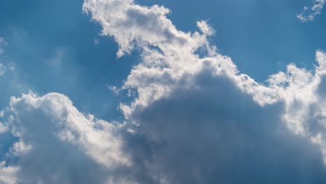 fast moving clouds in front of a blue sky with sunbeams as a timelapse 4k footage