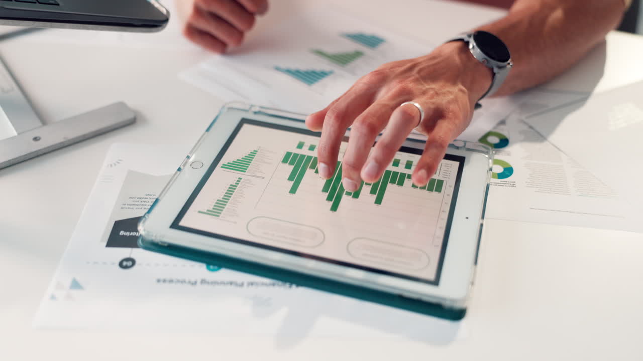 Close-up of Hand Analyzing Business Data on Digital Tablet