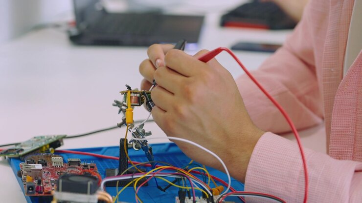 Ingegnere che testa un circuito elettronico con i puntali di un multimetro
