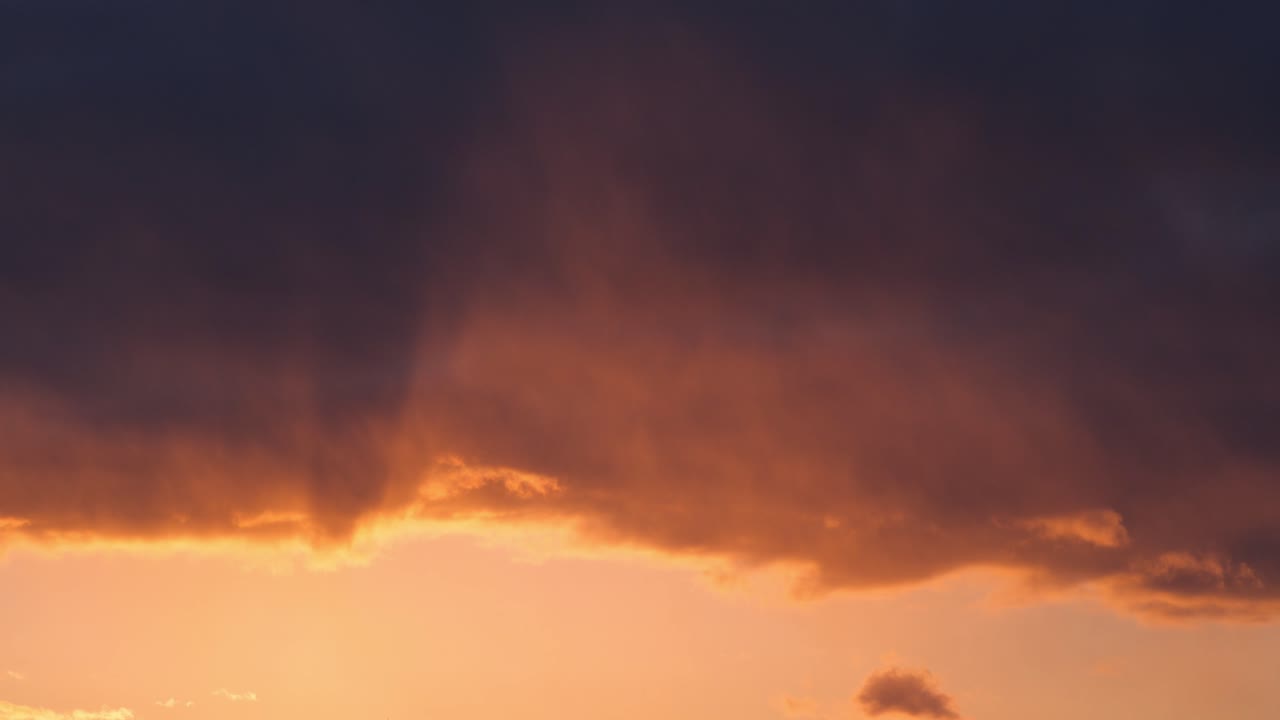 Dramatic orange and purple sunset clouds fill the sky in a wide of dusk light, natural backdrop background