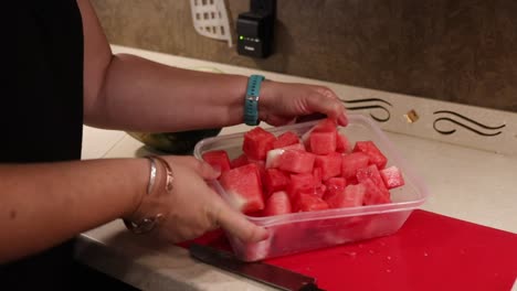 mujer recogiendo trozos de sandía cortados