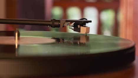 close up view of a turntable tonearm and needle with platter spinning, slow motion 4k