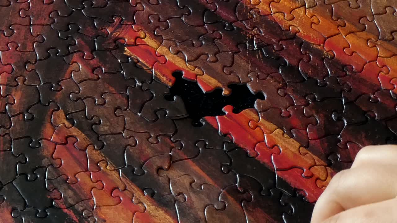 다채로운 퍼즐의 마지막 몇 조각을 완성하는 사람의 손