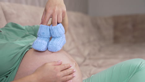 pregnant woman at home. young expecting woman holds baby in pregnant belly