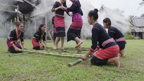 ethnic women in traditional attire performing a bamboo dance