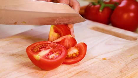 slicing tomatoes with a knife on wooden board