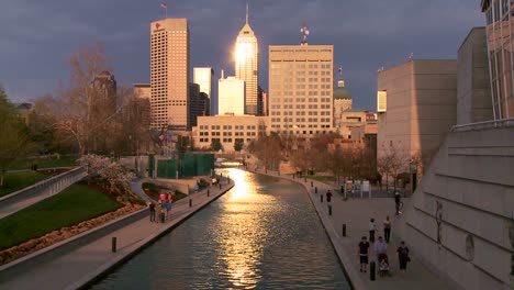 indianapolis indiana river walk at dusk with sun glinting off buildings