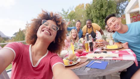 Feliz-Grupo-Diverso-De-Amigos-Tomándose-Selfie-En-La-Mesa-En-El-Jardín,-Cámara-Lenta