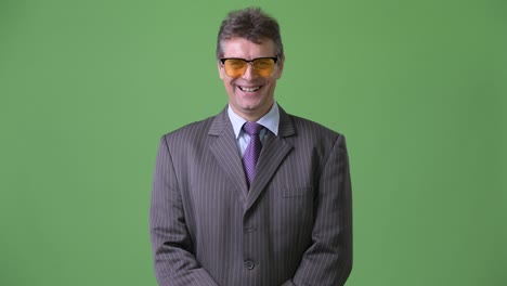 mature handsome businessman against green background