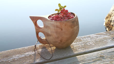 healthy nordic berries in traditional wooden kuksa cup