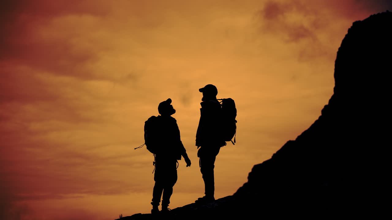 Hikers silhouetted against a sunset sky