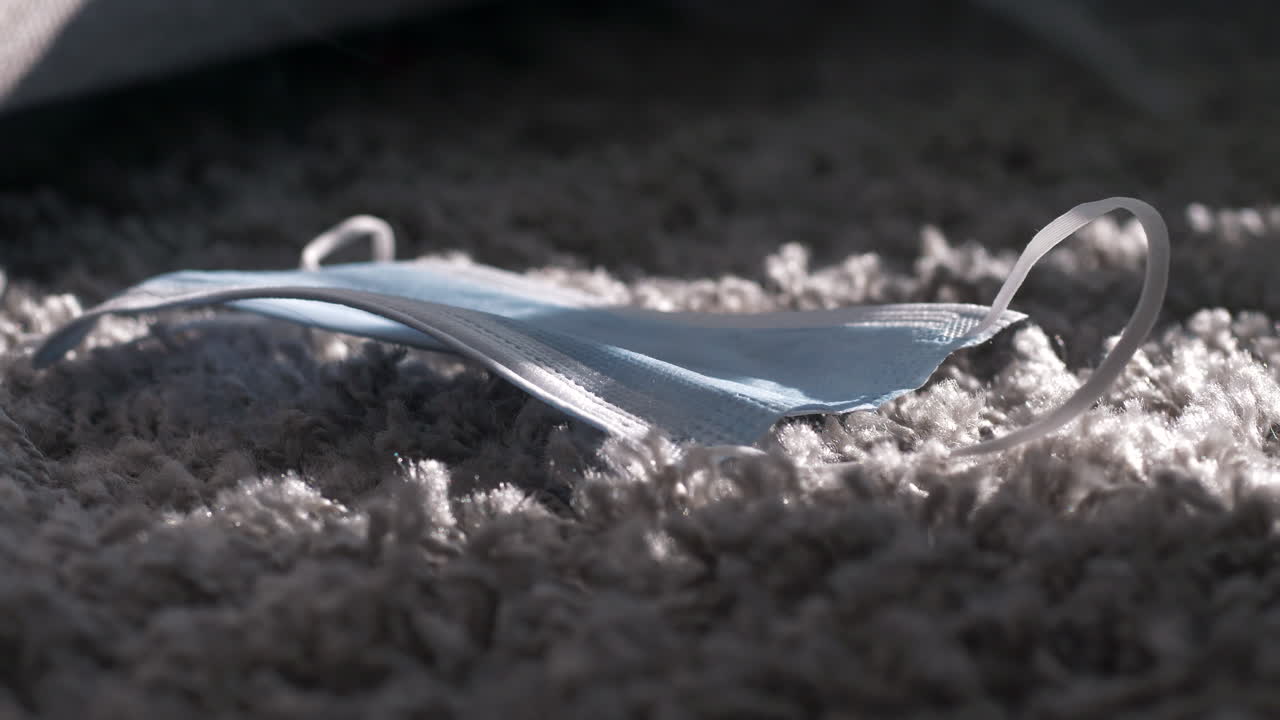 연무 안개가 낀 바닥 깔개에 covid-19 안면 마스크를 사용했습니다.