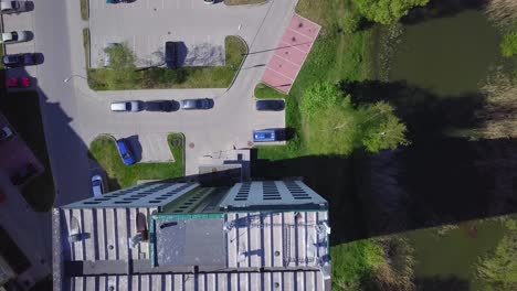 Aerial-birdseye-view-of-crowded-residential-district-apartment-building-rooftops-on-a-sunny-summer-day,-renovated-and-insulated-houses,-colorful-walls-of-the-facade,-drone-shot-moving-forward