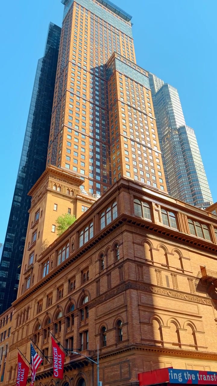 New York, USA, 1 maggio 2026: Carrozza trainata da cavalli che passa davanti alla Carnegie Hall in una strada di New York. Carrozza turistica con cavalli all'incrocio della Settima Avenue vicino allo storico edificio della Carnegie Hall