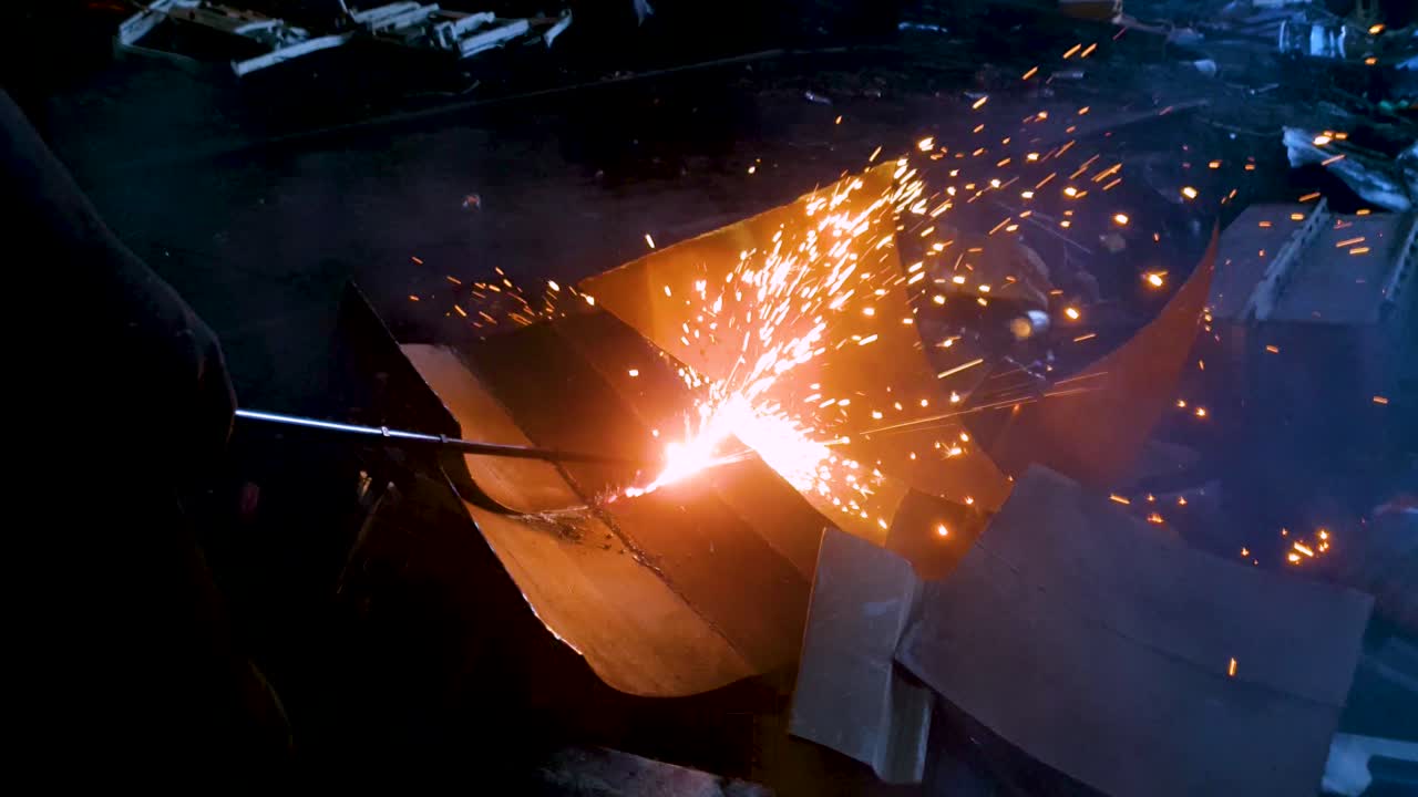 Slow motion of sparks produced during metal scrap cutting with gas cutter. Close up.